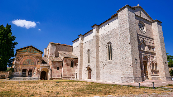 A suggestive wide angle view of the Church of San Francesco al Prato (Saint Francis of Assisi) and the oratory of San Bernardino, in the medieval heart of Perugia, in Umbria, central Italy. Built in Romanesque style starting from 1251, this splendid church was for a long time without a roof due to the continuous landslides of the hill below, it has returned to its former glory thanks to a series of restorations completed in 1926. The facade of the oratory of San Bernardino it was built in 1452 in the Renaissance style and decorated with bas-reliefs by Agostino di Duccio in 1457. Founded by the Etruscans on an ancient Umbrian settlement, Perugia is one of the most loved and visited medieval Italian cities, rich in artistic and architectural treasures that span almost three thousand years of history. The Umbria region, considered the green lung of Italy for its wooded mountains, is characterized by a perfect integration between nature and the presence of man, in a context of environmental sustainability and healthy life. In addition to its immense artistic and historical heritage, Umbria is famous for its food and wine production and for the quality of the olive oil produced in these lands. Super wide angle image in 16:9 and high definition format.