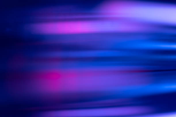 Defocused light leak. Bokeh neon glow. Sci-Fi glare. Blur fluorescent navy blue pink purple color flecks flare motion on dark futuristic abstract background.