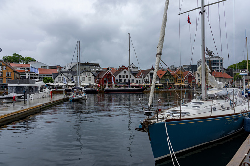 The Norwegian port of Stavanger, Norway, Europe. There are moored sailing ships in the foreground and dockside bars in the background.