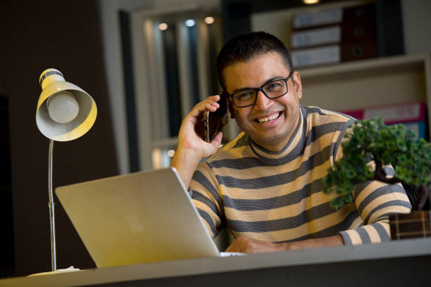 istock Man using laptop and phone at home office 1417981895