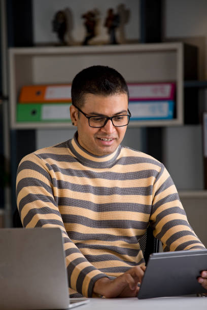 istock Man using laptop and digital tablet at home office 1417982329
