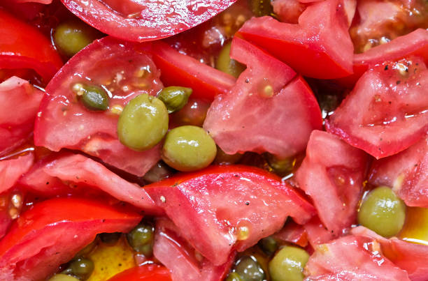 Close-up of tomato salad Mediterranean salad with tomatoes, olives and capers. caper stock pictures, royalty-free photos & images