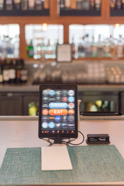 Tablet with swipe magnetic credit card reader to order food and drink at airport bar restaurant in Texas, USA stock photo
