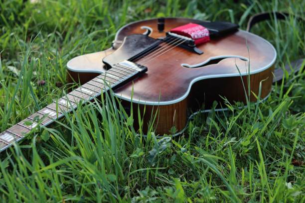 istock Wooden guitar in a green field 1417984082