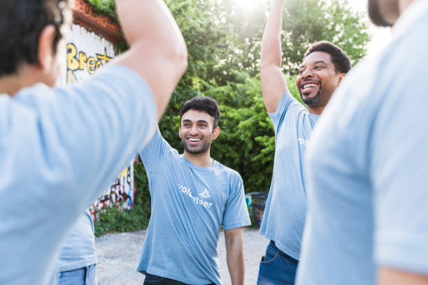 istock Diverse park clean-up volunteers smile and cheer 1417984764