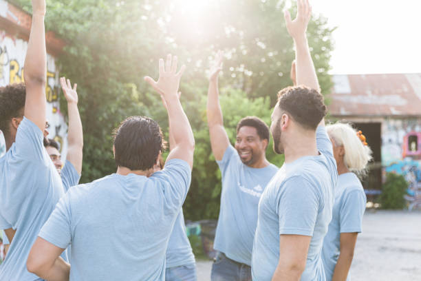 Multiracial group of volunteers cheer before work