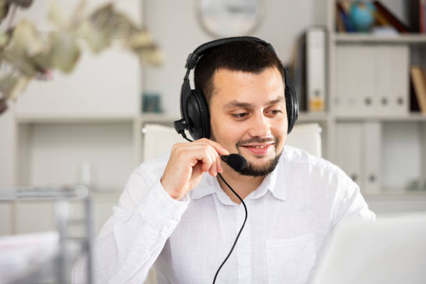 istock Smiling man with headset in his workplace in office 1417986132