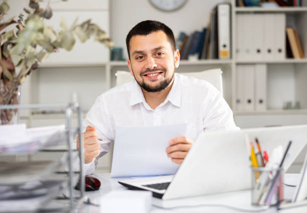 istock Positive man bookkeeper doing paperwork in office 1417986142