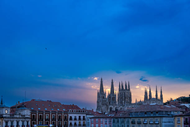 Gothic cathedral and square in Burgos, Spain at dusk.