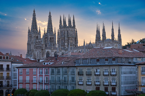 Gothic cathedral and square in Burgos, Spain at dusk.