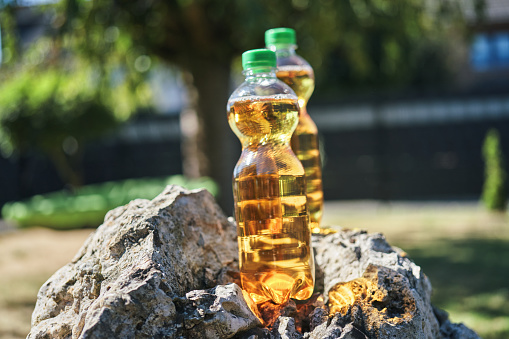 Apple Soda in Plastic Bottle with Park Background