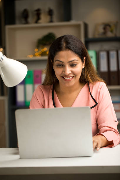 istock Happy woman using laptop at home 1417990428