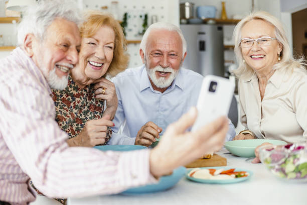 istock Senior group of friends using mobile phone during lunch 1417991341