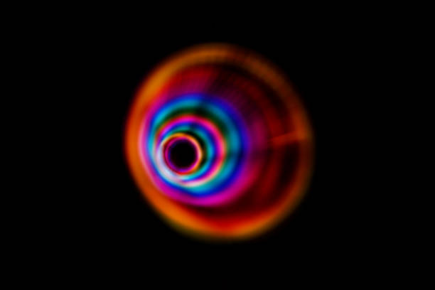 istock Multicolored light circles of different colors, yellow blue, red, blurred circle on a black background, photo was taken with a long exposure when the lanterns of rainbow colors were twisted 1417992448