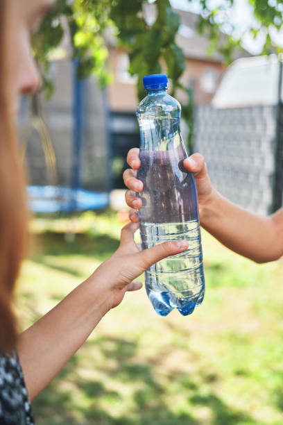 istock Young Teens Holding Plastic Bottle of Water 1417992629
