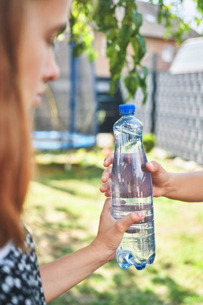 istock Young Teens Holding Plastic Bottle of Water 1417992806