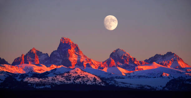 istock Sunset Light Alpen Glow on Tetons Teton Mountains wtih Moon Rising 1417992946