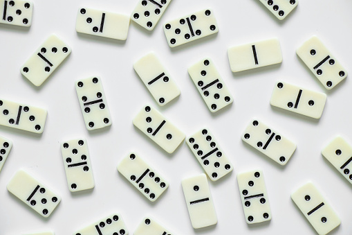 dominoes on a white background close-up, domino effect