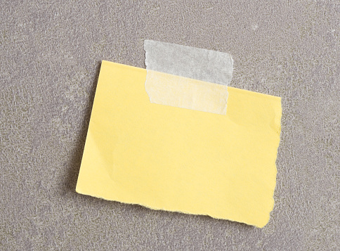 Piece of paper with tape on grey background
