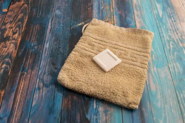 high angle view of a yellow washcloth with a piece of a white soap on a table