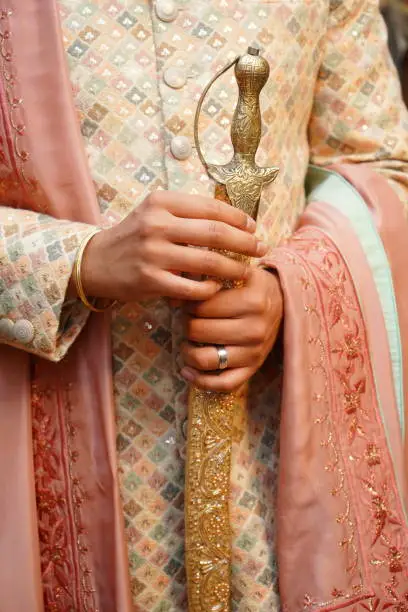 Hand man with suit wedding india with sword