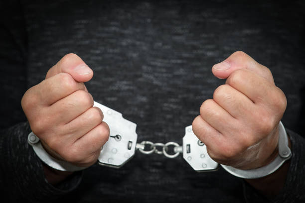 istock A criminal has been detained. Hands are wound back, handcuffs are put on to prevent aggression. 1418005977