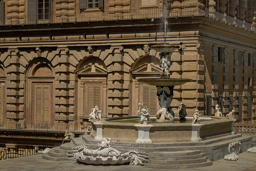 Florence, Italy - 12 august 2022: Monumental fountain with Pitti Palace in Boboli garden, Florence