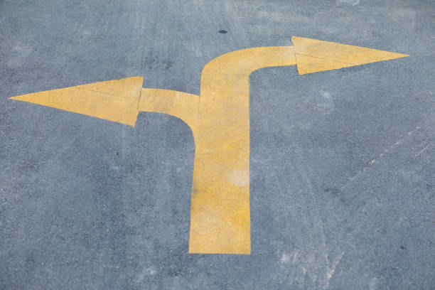 istock Two directional yellow arrow sign on street 1418008867