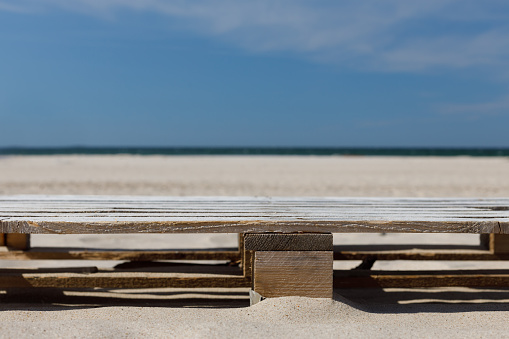 Wooden pallet against the beach on a sunny day. Shot from the front, copy space. Mock-up for zero waste product.
