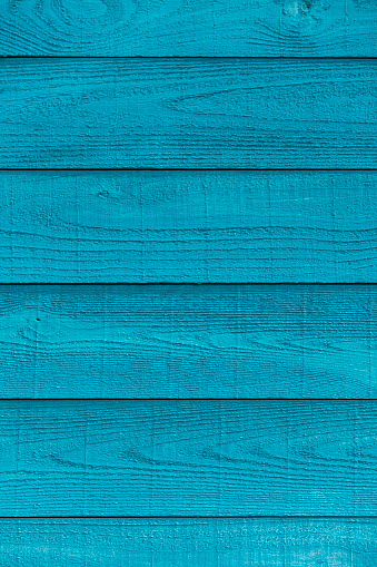 A turquoise colored raw sawn wooden plank wall background