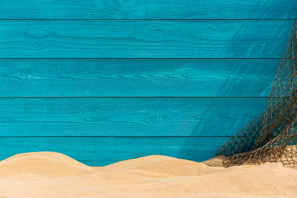 A turquoise colored raw sawn wooden plank wall and brown fishing net background