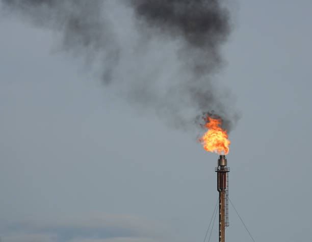 Gases burning into the atmosphere from an industrial flare stack at a gas processing plant in the UK. Flaring gases from an industrial natural gas processing plant in the UK. climate crisis photos stock pictures, royalty-free photos & images