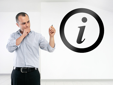 Businessman working on a transparent visual board and drawing “Information” sign