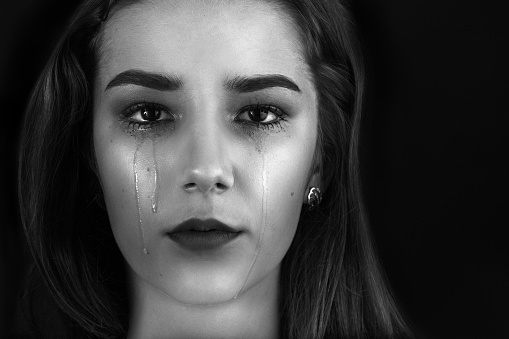 beautiful woman crying on black background, monochrome