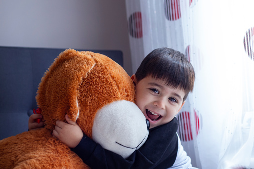cute little boy hugs his teddy bear