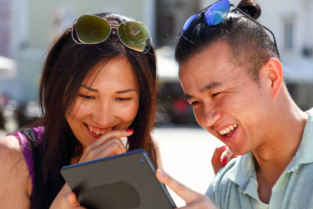 istock Asian couple looking at photos on a digital tablet 1418022367