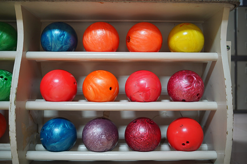 A rack of old worn bowling balls.