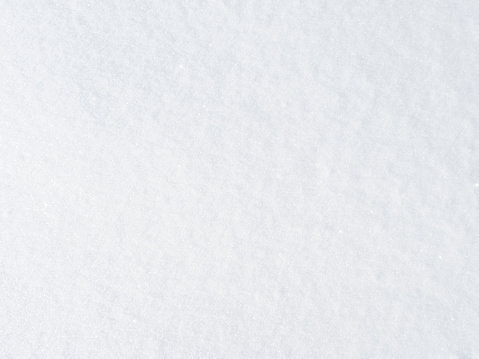 background of fresh snow texture in bright white, sparkling in the sun.