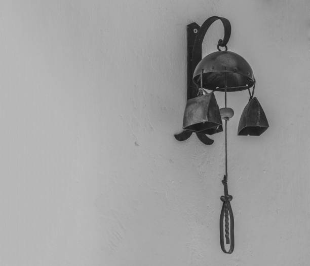 istock old rustic warning bell cow bell hanging from the white wall in black and white 1418025563