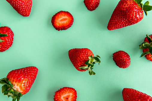 Strawberry slices on green background.