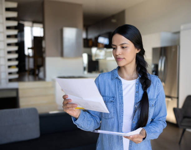 istock Woman at home reading a letter in the mail 1418029802