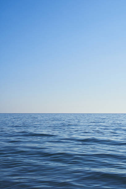 istock Dark blue water from the sea with blue sky. Light comes from the right. Vertical format, also suitable as a poster or background. Free space for text or objects. 1418032302