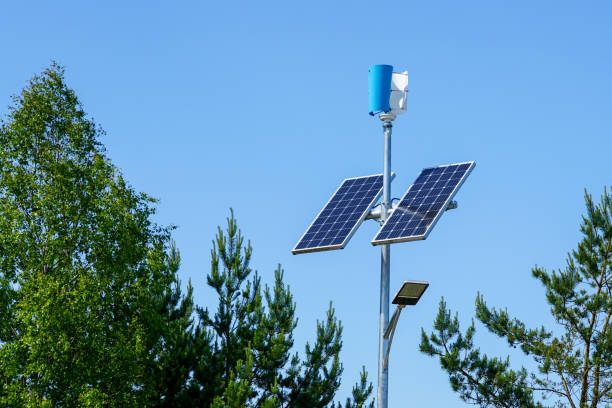 A pole with a innovative LED street light powered by solar panels and vertical wind turbine Pole with innovative LED street light powered by solar cells and small vertical wind generator, blue sky background solar street lights stock pictures, royalty-free photos & images