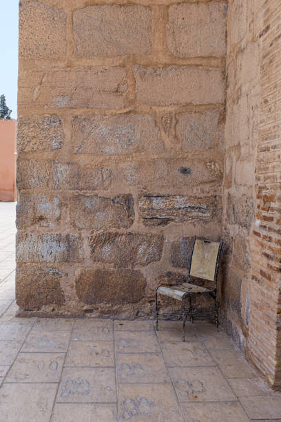 istock Old empty wooden chair on a corner of a old brick wall 1418036149