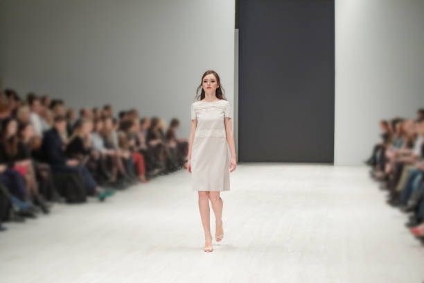 portrait féminin d’une belle femme qui travaille mannequin au défilé de la semaine de la mode. photographie des coulisses, dans les coulisses de la nouvelle collection de vêtements. vêtements de fille par mode desiner et aller sur le podium - défilé photos et images de collection