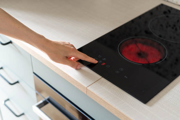istock hand press button on electric stove in kitchen 1418039032