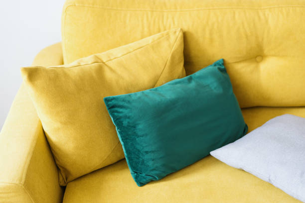 istock sofa with mustard velvet textile and pillows, closeup 1418040332