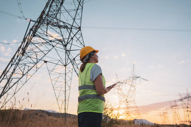 istock Female electrical engineer working near to High voltage tower. 1418043881