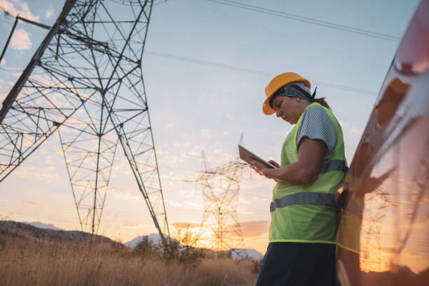 istock Women electrical engineer while working near to high voltage tower 1418043990