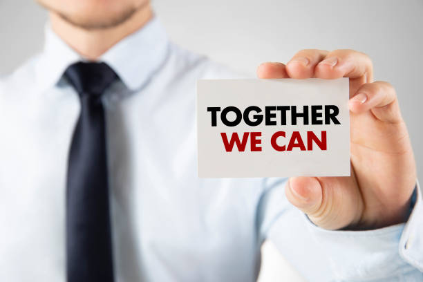 istock Businessman Holding a Card with Text Together We Can 1418045092